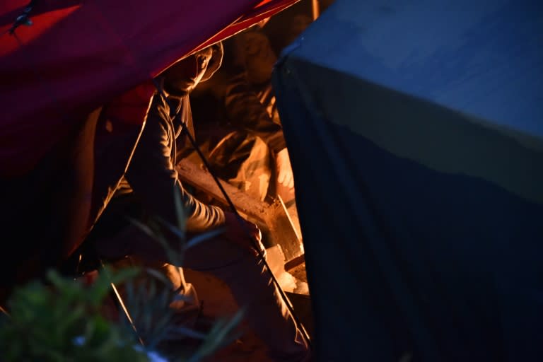 A migrant sits under a tent in the "Jungle" migrant camp in Calais, northern France, on October 24, 2016