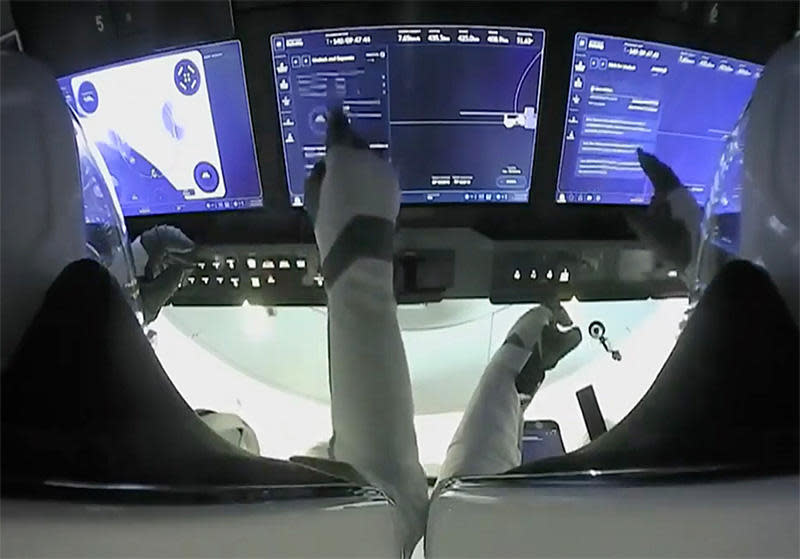 Crew Dragon commander Mike Hopkins, left, and Victor Glover use the spacecraft's touch-screen displays to monitor the progress of a move from one docking port to another to clear the way for arrival of a fresh crew later this month and a cargo ship this summer.  / Credit: NASA TV