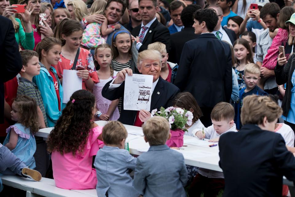 Trump shows a note he wrote while writing&nbsp;notes to service members with children.