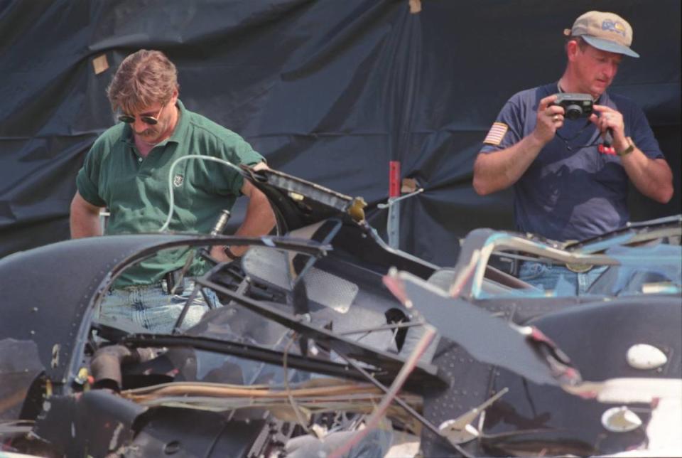 In this May 1998 file photo, Paul Coombes, director of maintenance for U.S. Helicopters in Marshville, at left, and National Transportation Safety Board investigator Butch Wilson examine the wreckage of a Bell JetRanger helicopter that had crashed on U.S. 74, killing five people. 1998 Observer file photo