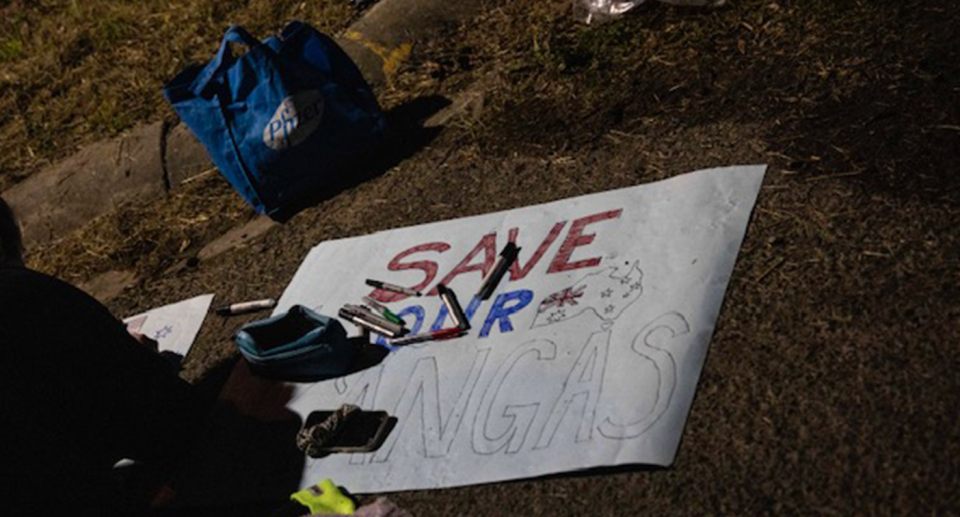 Someone painting a protest sign saying Save Our Kangas.