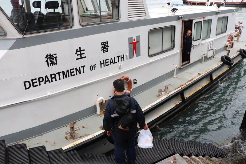 Government officer gets on a Department of Health ship before it heads to the Kai Tak Cruise Terminal, where the World Dream ship that had been denied entry in Taiwan's Kaohsiung amid concerns of coronavirus infection on board is docked, in Hong Kong