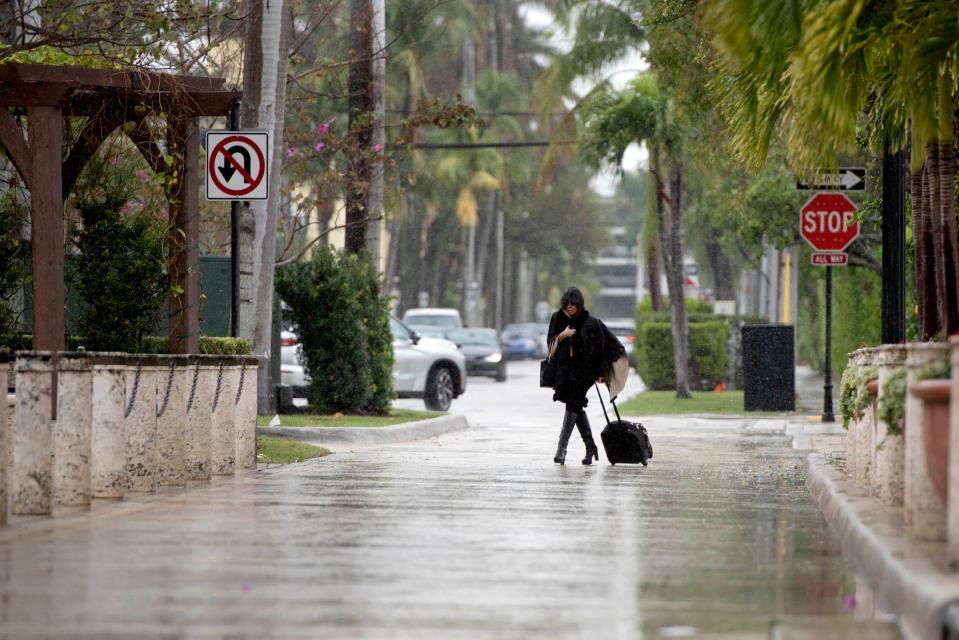 A pedestrians braves cool raining weather in Palm Beach, California in Dec. 28, 2023.