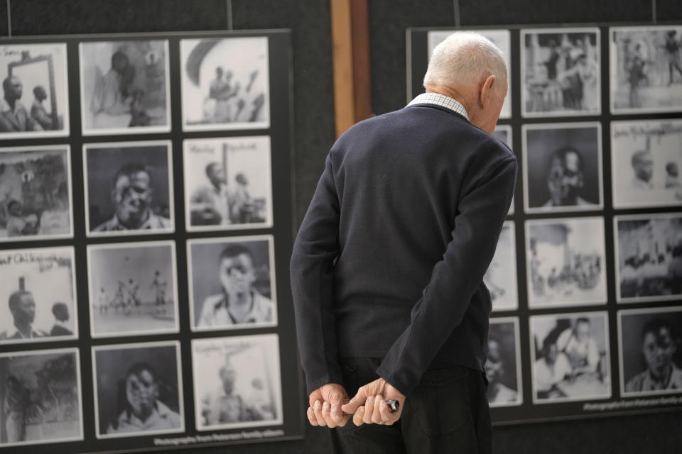 An elderly man walks past photographs of young Black students at Cyrene Mission School at the National Gallery of Zimbabwe, Tuesday July 26, 2022. The Black students portraits are part of a historic exhibit, "The Stars are Bright," now showing in Zimbabwe for the first time since the collection left the country more than 70 years ago. (AP Photo/Tsvangirayi Mukwazhi)