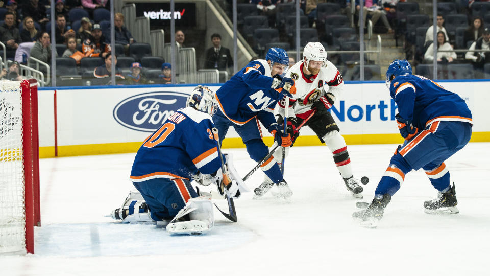 New York Islanders defenseman Adam Pelech (3) fights for control of the puck against Ottawa Senators right wing Claude Giroux (28) as New York Islanders goaltender Ilya Sorokin (30) and New York Islanders defenseman Ryan Pulock (6) keep an eye on the puck during the first period of an NHL hockey game Tuesday, Feb. 14, 2023, in Elmont, N.Y. (AP Photo/Eduardo Munoz Alvarez)