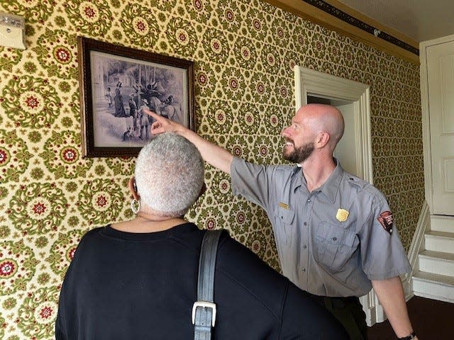 Kevin Bryant, a ranger with the National Park Service, showed a visitor a picture of abolitionist Frederick Douglass earlier this month at the Frederick Douglass National Historic Site in Washington, D.C.
