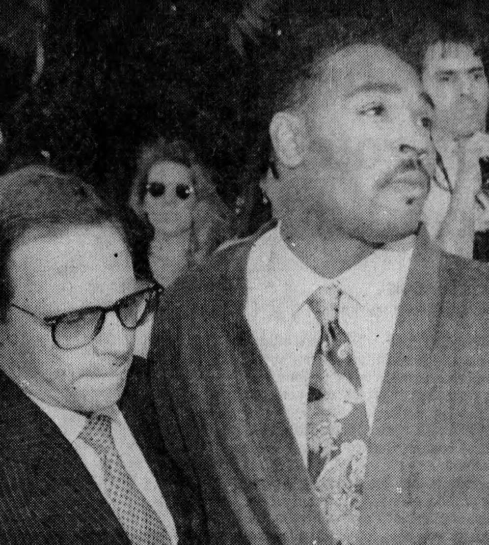 Rodney King, center, and his attorney, Steve Larman, left, speak with reporters in Los Angeles on Friday, May 1, 1992. King pleaded for an end to the rioting and looting.