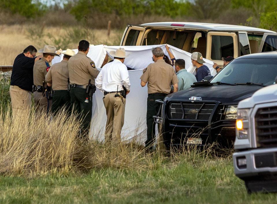 Officials investigate the scene where migrants were found trapped in a train car, Friday, March 24, 2023 in Ulvalde, Texas. Union Pacific railroad said in a statement that the people were found in two cars on the train traveling east from Eagle Pass bound for San Antonio. (William Luther/The San Antonio Express-News via AP)