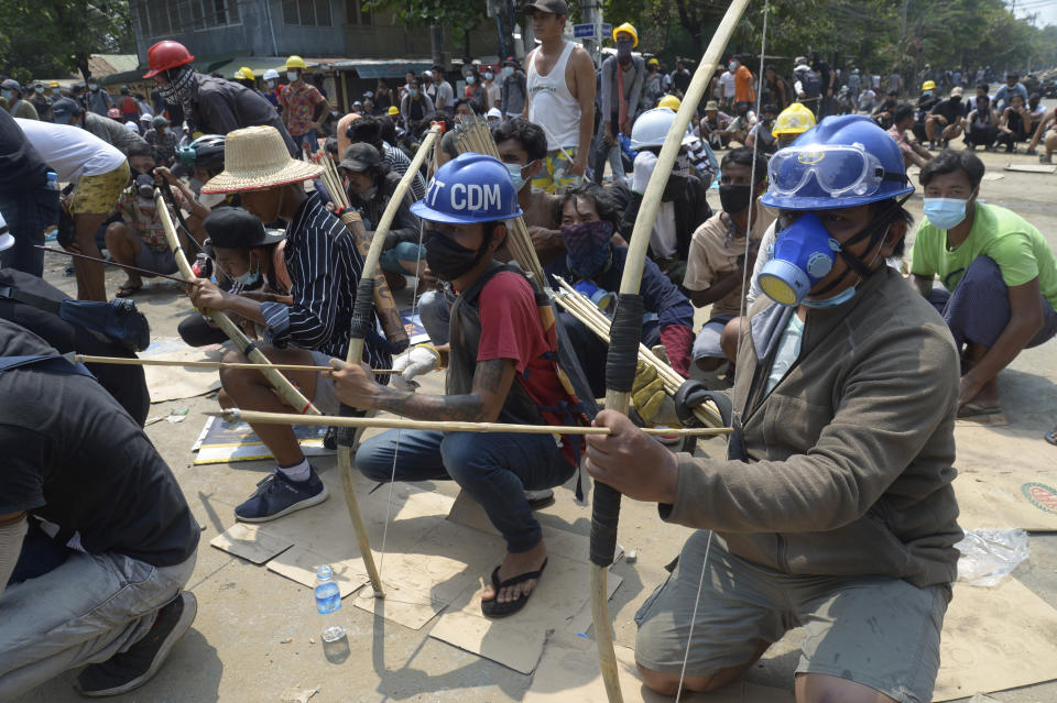 FILE - In this March 27, 2021, file photo, anti-coup protesters prepare makeshift bow and arrows to confront police in Thaketa township Yangon, Myanmar. The military takeover of Myanmar early in the morning of Feb. 1 reversed the country's slow climb toward democracy after five decades of army rule. But Myanmar's citizens were not shy about demanding their democracy be restored. (AP Photo, File)