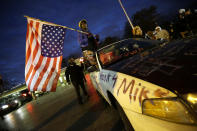 <p>Gina Gowdy holds an upside-down American flag Monday, Nov. 24, 2014, in Ferguson, Mo., more than three months after an unarmed black 18-year-old man was shot and killed there by a white policeman. Ferguson and the St. Louis region are on edge in anticipation of the announcement by a grand jury whether to criminally charge Officer Darren Wilson in the killing of 18-year-old Michael Brown. (AP Photo/Charlie Riedel) </p>