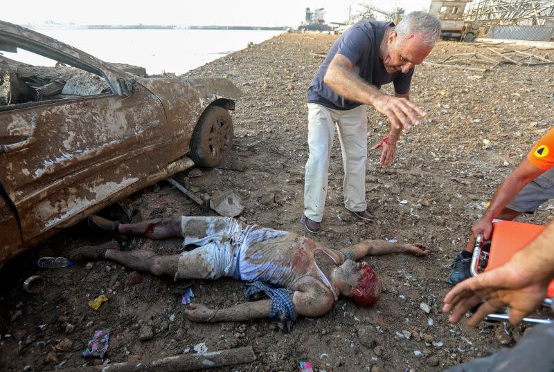 MATERIAL SENSIBLE. ESTA IMAGEN PUEDE LATIMAR O PERTURBAR: Un hombre herido que quedó atrapado debajo de un vehículo después de una explosión en el área portuaria de Beirut es ayudado por un grupo de personas. Líbano, 4 de agosto de 2020.