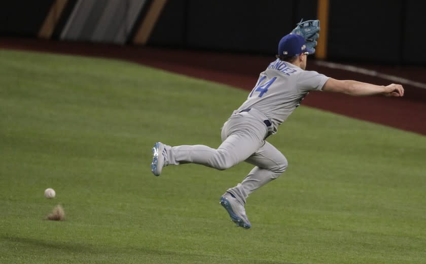 Arlington, Texas, Thursday, October 15, 2020. Los Angeles Dodgers second baseman Enrique Hernandez (14) can't grab an rbi single hit by Atlanta Braves second baseman Ozzie Albies (1) during a sixth inning rally in game four of the NLCS at Globe Life Field. (Robert Gauthier/ Los Angeles Times)