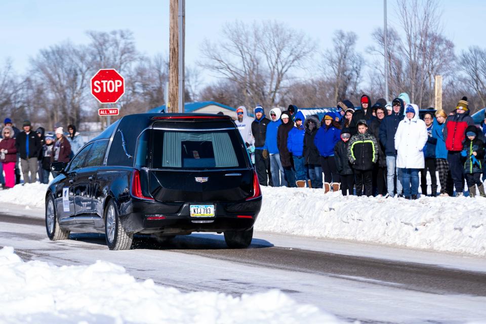 The hearse carrying Perry Principal Dan Marburger is welcomed by swaths of community members Tuesday, Jan. 16, 2024, in Perry, IA.