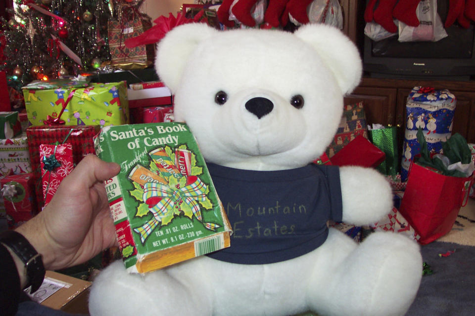 In this Ryan Wasson family photograph, a box of "Santa's Book of Candy," which was sewn inside the gift toy bear by Eric Wasson, is held by Ryan Wasson at Christmas in December 2004, in Tamworth, N.H. Two New Hampshire brothers have gotten their holiday regifting skills down to an art, and have been passing the same hard candy treats back and forth for over 30 years. Starting in 1987, Ryan gave the treat to his brother as a joke for Christmas, knowing that Eric wouldn't like it. (Ryan Wasson family photograph via AP)