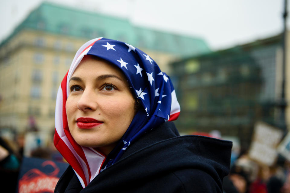 A woman wears a US flag like a hijab during a protest of US Democrats Abroad in front of the Brandenburg Gate in Berlin on January 21, 2017, one day after the inauguration of the US President.&nbsp;