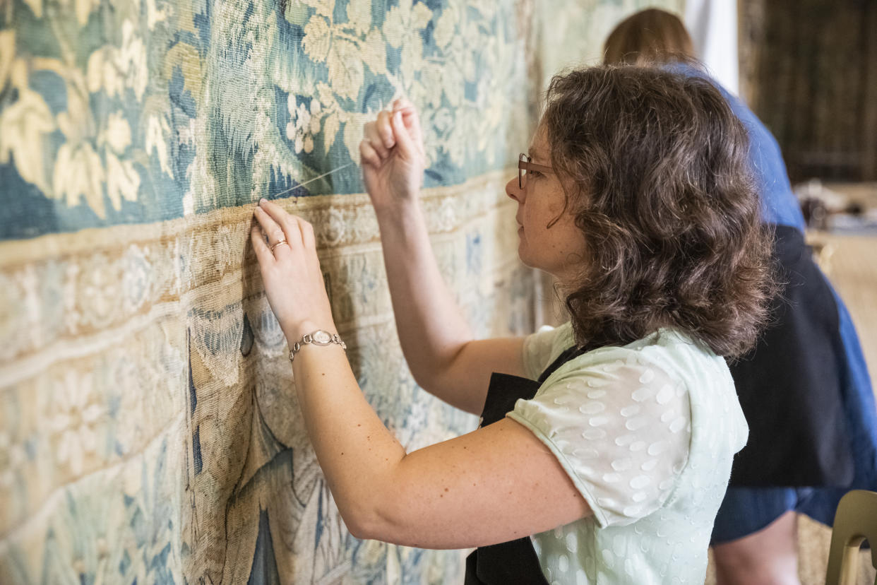 Staff make final adjustments to the tapestries at Hardwick Hall, Derbyshire (James Dobson/National Trust)