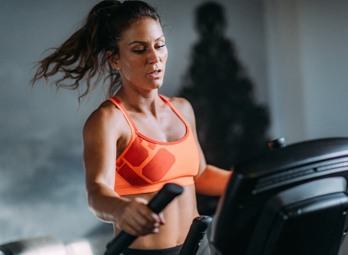 fit woman on the elliptical, concept of treadmill or elliptical which is more effective