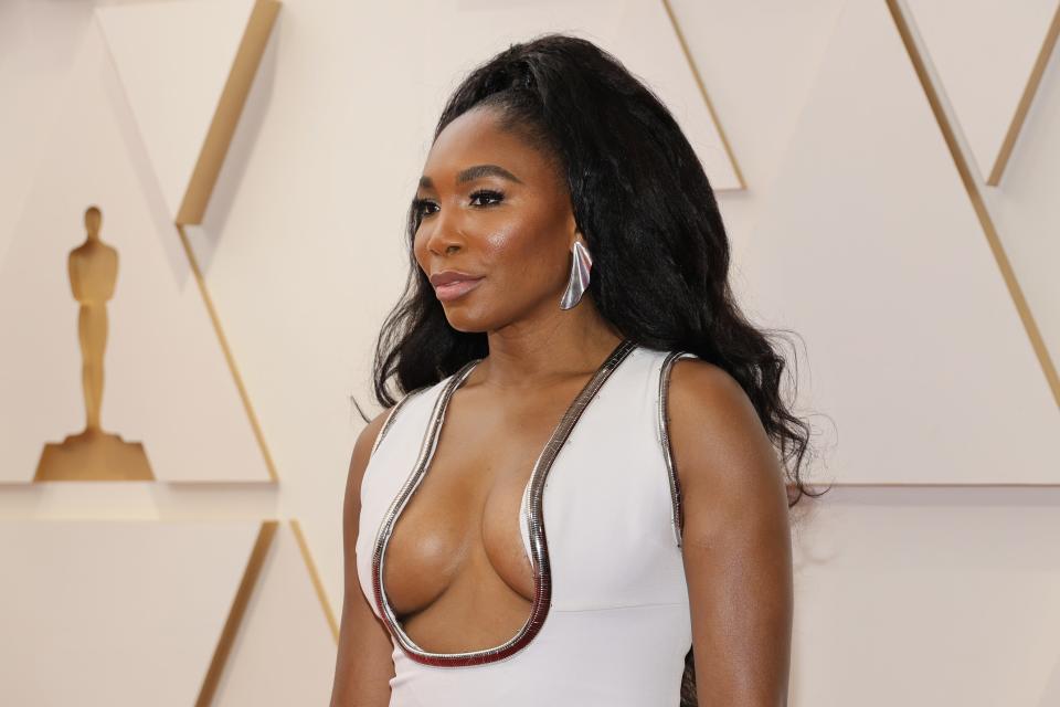 Venus in a white gown with a low rounded neckline that comes close to her nipples.