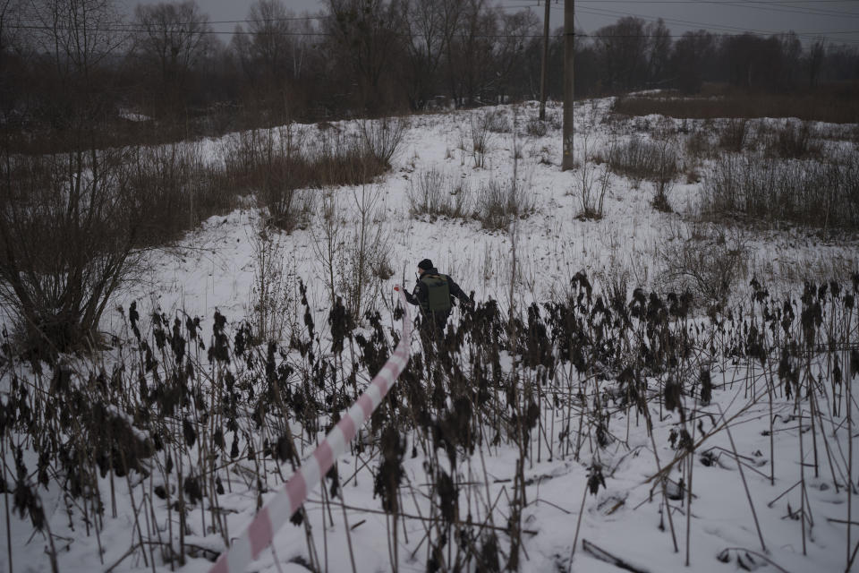 A Ukrainian police officer cordons an area where the remains of a rocket landed after it was allegedly shot down following a Russian attack in Kyiv, Ukraine, Friday, Dec. 16, 2022. Ukrainian authorities reported explosions in at least three cities Friday, saying Russia has launched a major missile attack on energy facilities and infrastructure. Kyiv Mayor Vitali Klitschko reported explosions in at least four districts, urging residents to go to shelters. (AP Photo/Felipe Dana)