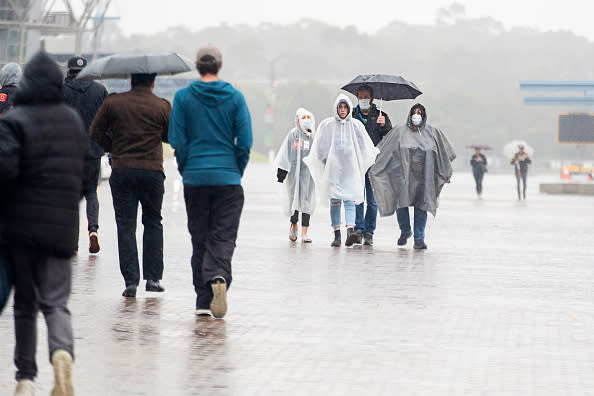 Football fans are seen arriving at ANZ Stadium in the rain in Sydney, Australia. 