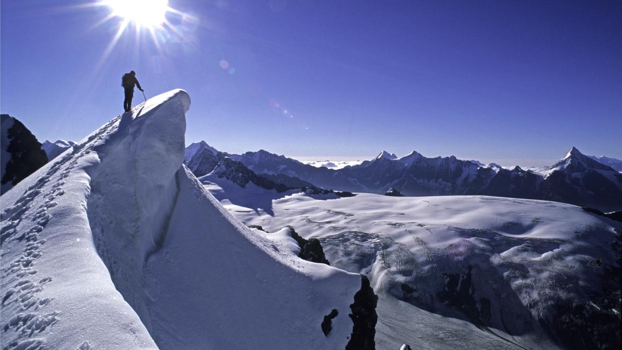  Mountaineer climbing along a snowy cornice, very exposed. 