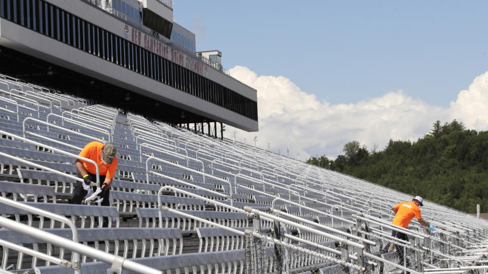 Cleaners, who will be working during the race, clean handrails during a walkthrough at the New Hampshire Motor Speedway, Friday, July 31, 2020, in Loudon, N.H., in preparation for this Sunday's Foxwoods 301 NASCAR auto race. (AP Photo/Charles Krupa)