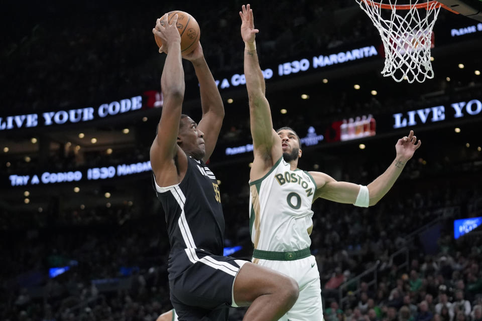 Memphis Grizzlies center Trey Jemison (55) shoots at the basket as Boston Celtics forward Jayson Tatum (0) defends in the first half of an NBA basketball game, Sunday, Feb. 4, 2024, in Boston. (AP Photo/Steven Senne)