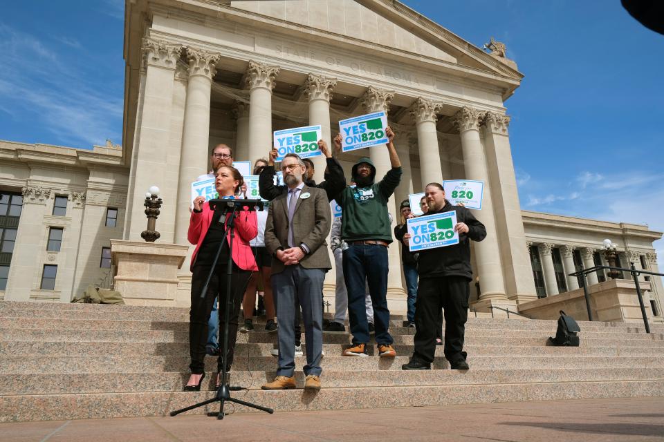 Michelle Tilley, left, and Ryan Kiesel with the Yes on 820 campaign speak to the media on the south plaza of the Capitol.