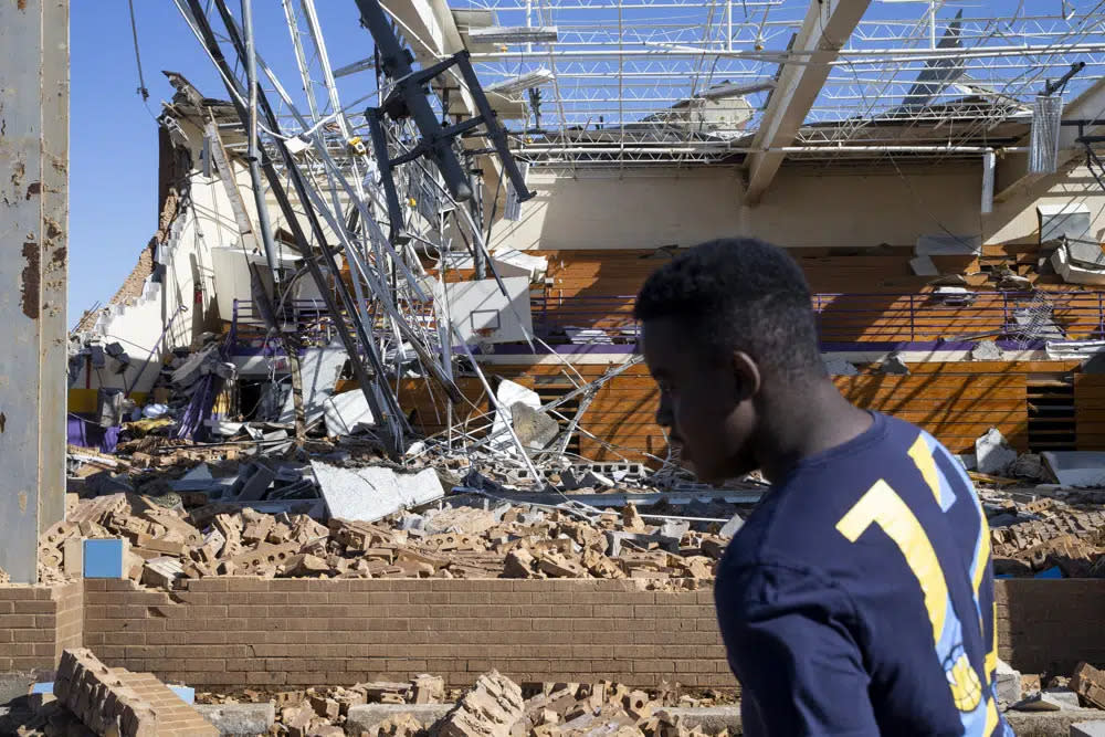 Jeremiah Burrell, 14, walks past the destroyed gym at Crestview Elementary School in Covington, Tenn., on Saturday, April 1, 2023. A severe storm or possible tornado hit the area on Friday night. (Chris Day/The Commercial Appeal via AP)