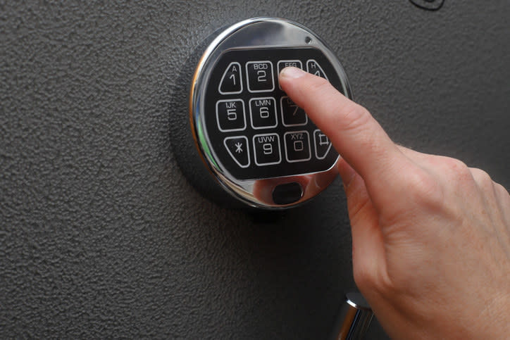 A person entering the code to a safe