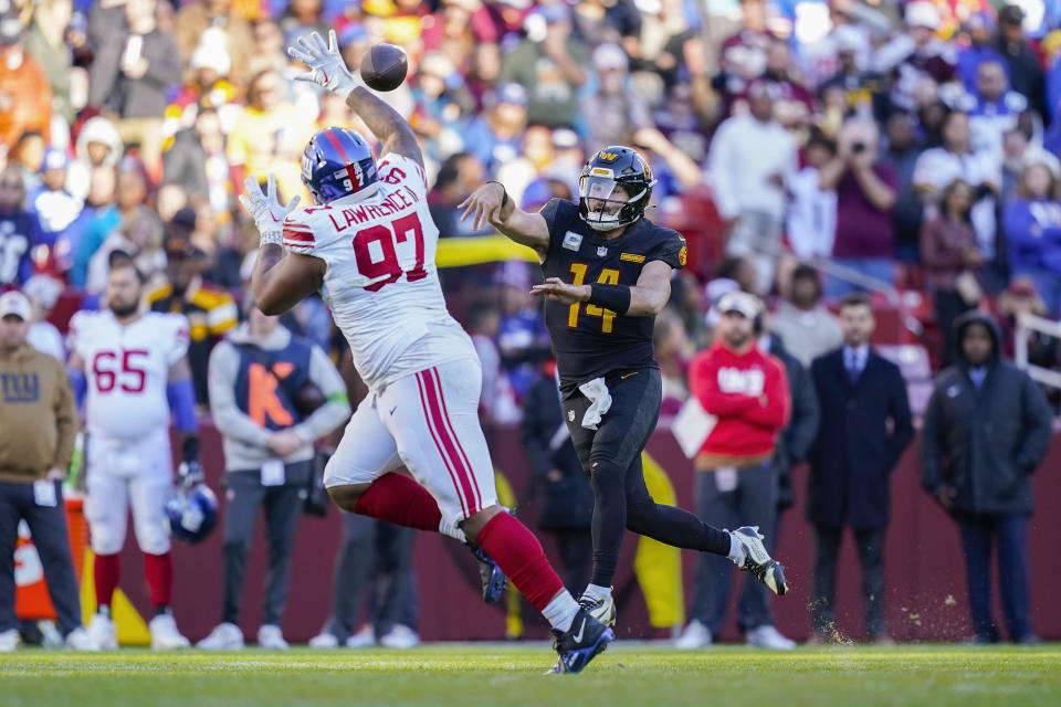 Washington Commanders quarterback Sam Howell (14) throwing the ball over New York Giants defensive tackle Dexter Lawrence II (97) during the second half of an NFL football game, Sunday, Nov. 19, 2023, in Landover, Md. (AP Photo/Stephanie Scarbrough)