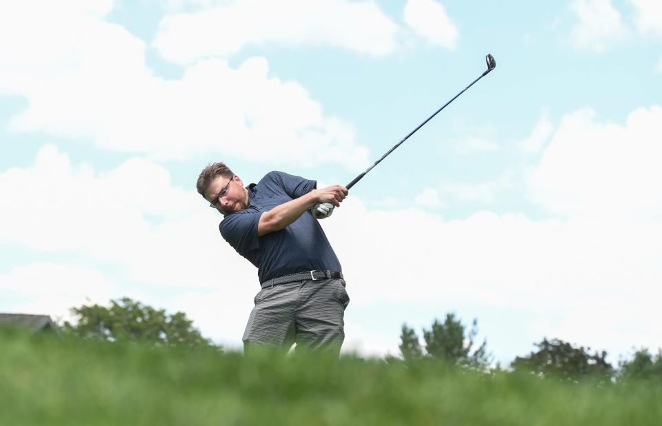 Ryan Lewis of the Akron Beacon Journal tees off at the 17th hole of Firestone Golf Club’s South Course on Monday in Akron.