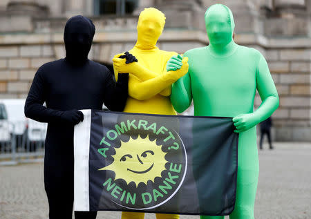 Environmental activists pose for photographers near the German Parliamentary Society offices during the exploratory talks about forming a new coalition government held by CDU/CSU in Berlin, Germany, October 26, 2017. The words read "Nuclear power? No thank you." REUTERS/Fabrizio Bensch