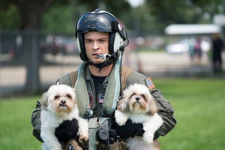Naval Aircrewman (Helicopter) 2nd Class Jansen Schamp, a native of Denver, Colorado rescues two dogs at Pine Forrest Elementary School, a shelter that required evacuation after flood waters from Hurricane Harvey reached its grounds in Vidor, Texas, U.S. August 31, 2017. U.S. Navy/Mass Communication Specialist 1st Class Christopher Lindahl/Handout via REUTERS