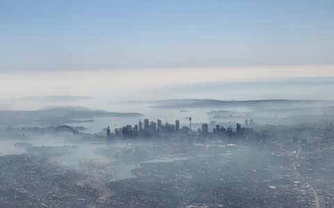 An image taken on a smart phone from a plane window shows smoke haze blanketing Sydney - Credit: Reuters/Stringer