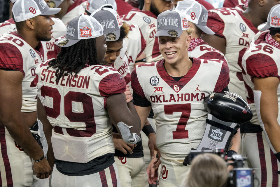 Oklahoma quarterback Spencer Rattler (7) is congratulated by running back Rhamondre Stevenson (29) as he holds the Most Outstanding Player trophy after their 27-21 win over Iowa State in the Big 12 Conference championship NCAA college football game, Saturday, Dec. 19, 2020, in Arlington, Texas. (AP Photo/Jeffrey McWhorter)