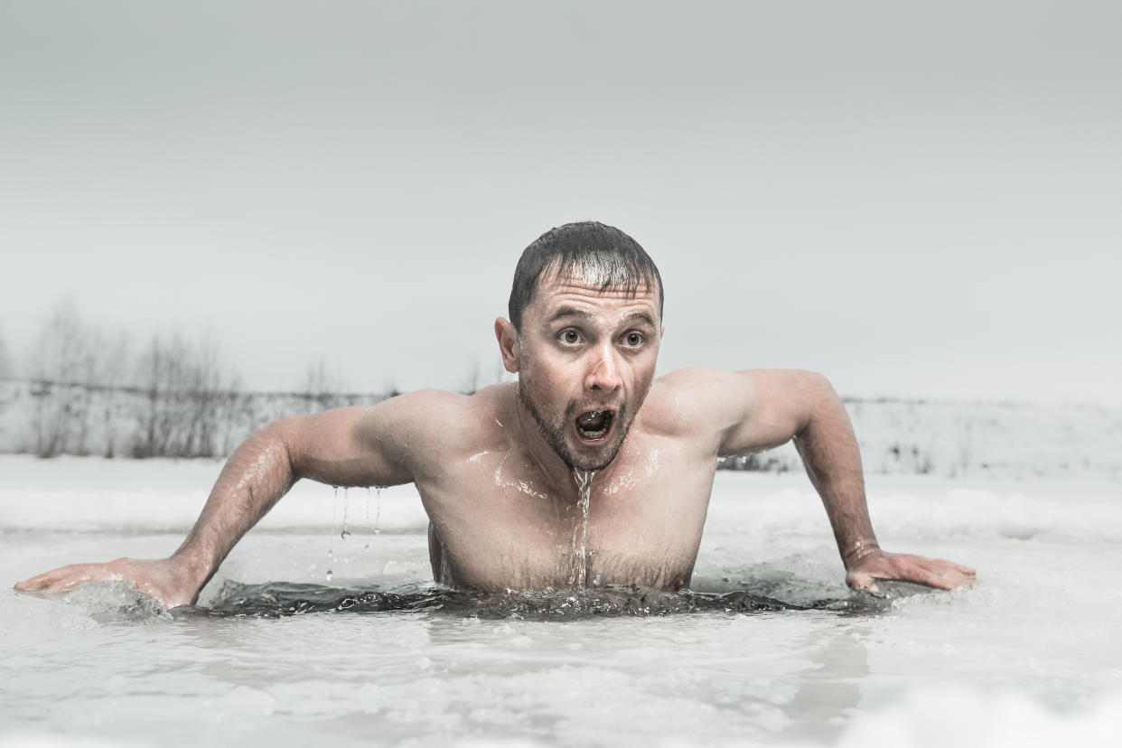 Man swimming in the ice hole with emotional face