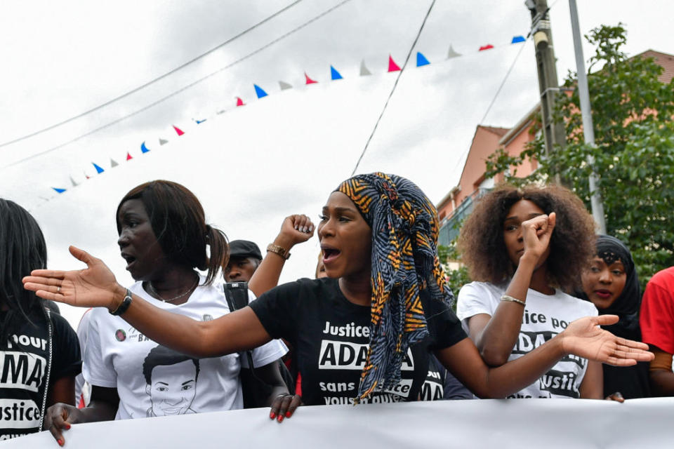 Assa Traore (C), the elder sister of late Adama Traore, who died during his arrest by the police in July 2016, wearing a tee-shirt reading 'Justice for Adama, without justice, you won't have peace' delivers a speech during a commemorative march on July 22, 2017 in Beaumont-sur-Oise, northeast of Paris. | Julien Mattia—Getty