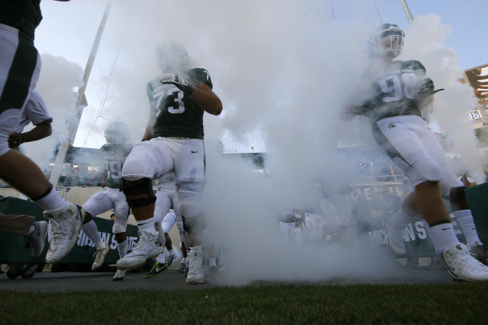 Michigan State players run onto the field before an NCAA college football game against Utah State, Friday, Aug. 31, 2018, in East Lansing, Mich. (AP Photo/Al Goldis)