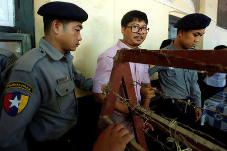 Detained Reuters journalist Wa Lone is escorted by police before a court hearing in Yangon, Myanmar May 16, 2018. REUTERS/Ann Wang