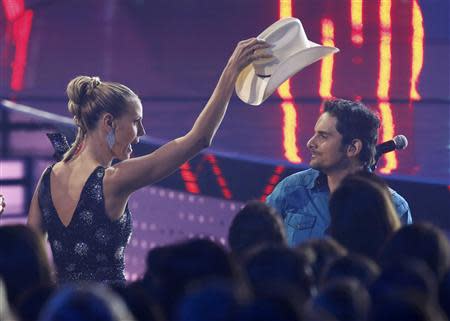 Model Heidi Klum tries to replace singer Brad Paisley's hat as he performs "The Mona Lisa" at the 2014 People's Choice Awards in Los Angeles, California January 8, 2014. REUTERS/Mario Anzuoni