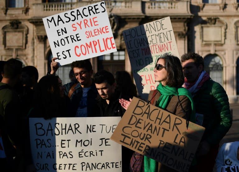 Signs read "Massacre in Syria, our silence is an accomplice" and "Bachar to the International Criminal Court" during a protest in support of Aleppo's population in Marseille, France