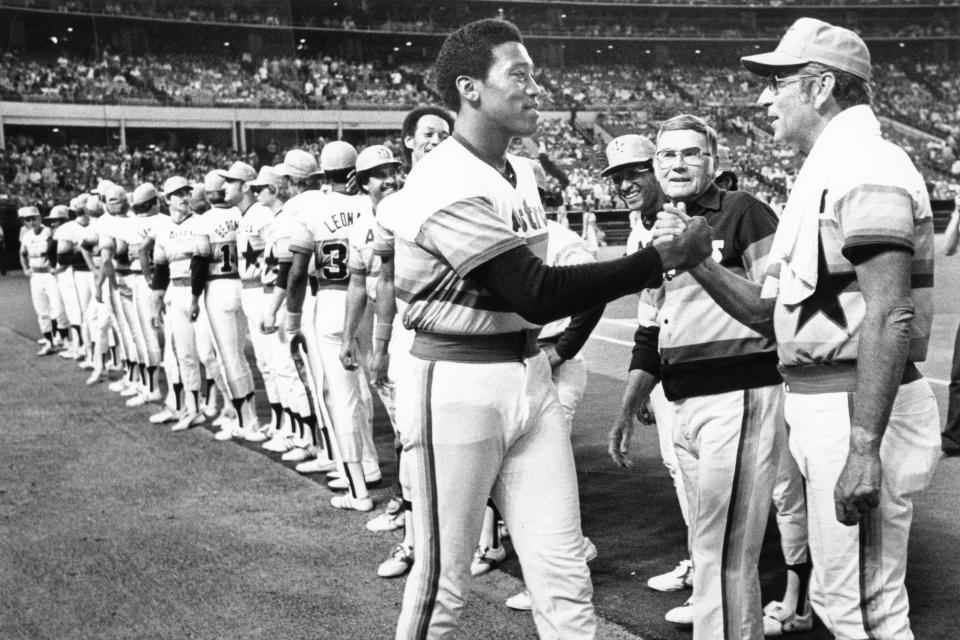 FILE - In this April 25, 1980, file photo, Houston Astros pitcher J.R. Richard accepts congratulations from pitching coach Mel Wright during a ceremony before a baseball game at the Astrodome in Houston. Richard, a huge, flame-throwing right-hander who spent 10 years with the Astros before his career was cut short by a stroke, has died, the team announced, Thursday, Aug. 5, 2021. He was 71. (Jim McNay/Houston Chronicle via AP)