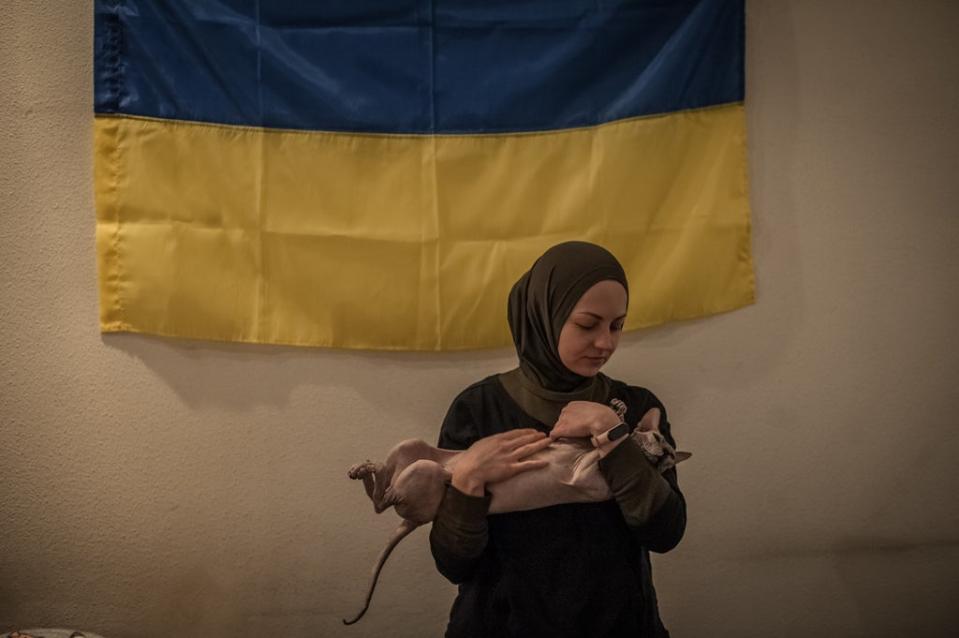 Viktoria with her cat in a volunteer centre where she and other volunteers help locals with food and the army with medical equipment (Alina Smutko)