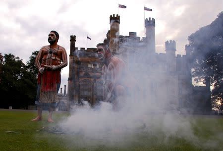 Australian Aborigines wearing traditional dress attend a small fire of gum leaves in front of Government House as part of a welcoming ceremony in Sydney, Australia, June 28, 2017. REUTERS/David Gray