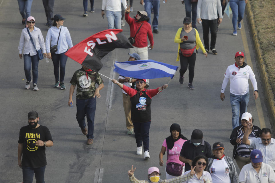 A person marches waving the Sandinista National Liberation Front banner and a Nicaraguan national flag march during a pro-government demonstration in Managua, Nicaragua, Saturday, Feb. 11, 2023. (AP Photo)