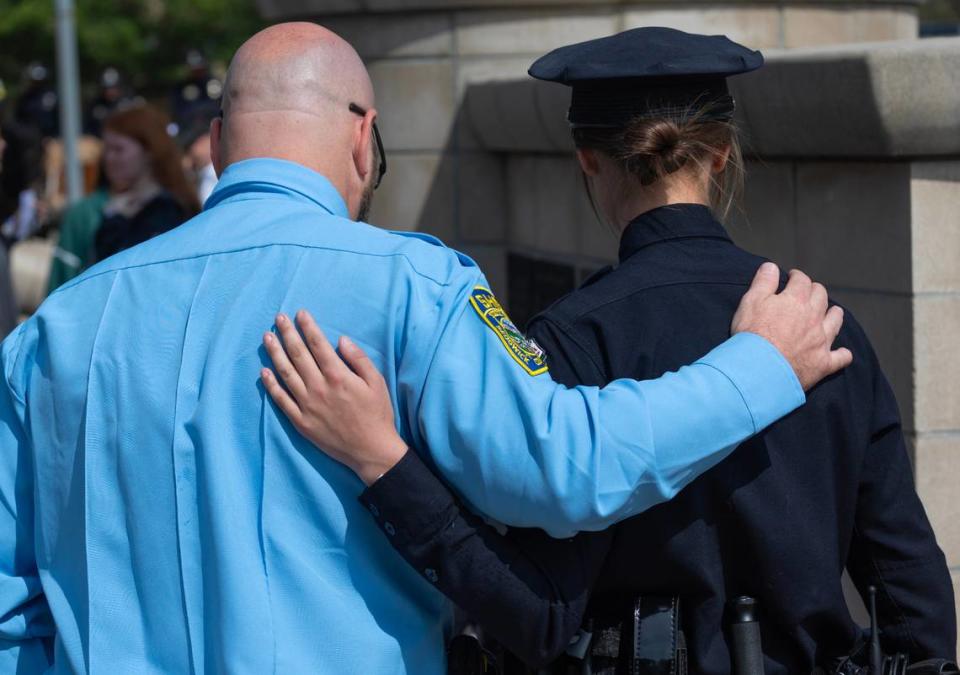 A Wichita Police officer and a Sedgwick County Sheriff’s officer stand arm in arm as then pay respects to fallen law enforcement officers from Sedgwick County.