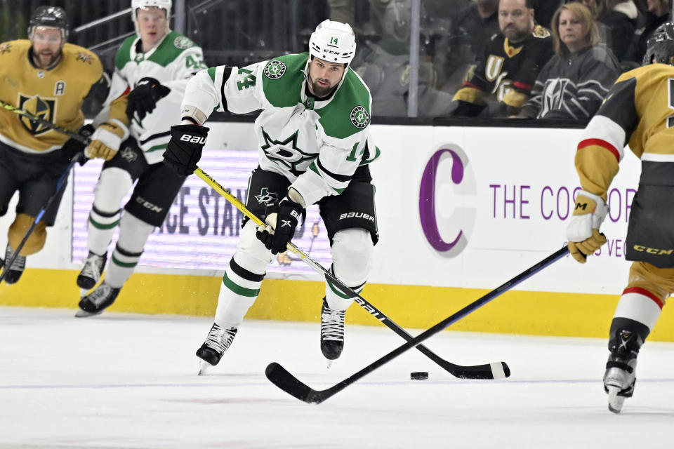 Dallas Stars left wing Jamie Benn (14) skates with the puck against the Vegas Golden Knights during the first period of an NHL hockey game Saturday, Feb. 25, 2023, in Las Vegas. (AP Photo/David Becker)