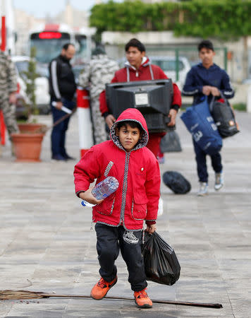 Syrian refugee boys hold belongings as they prepare to return to Syria, in Beirut, Lebanon, December 6, 2018. REUTERS/Jamal Saidi