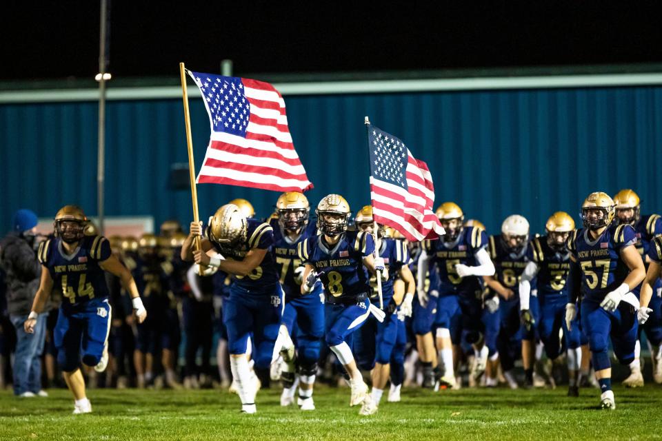 New Prairie players run out with American Flags before the New Prairie vs. Northridge regional championship football game Friday, Nov. 11, 2022 at New Prairie High School in New Carlisle.